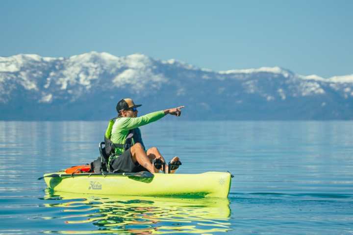 a man riding on the back of a boat in a body of water
