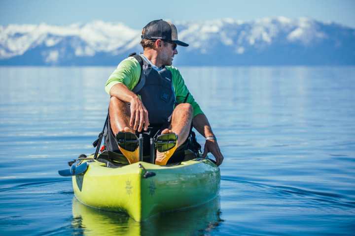 a man riding on the back of a boat in a body of water