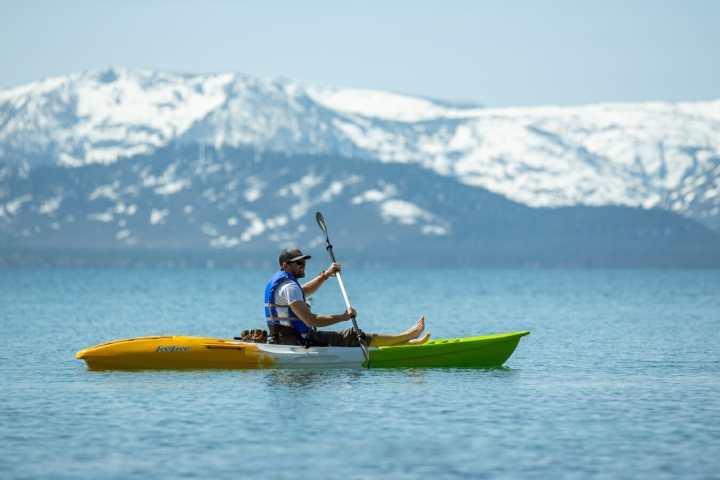 a man riding on the back of a boat in a body of water