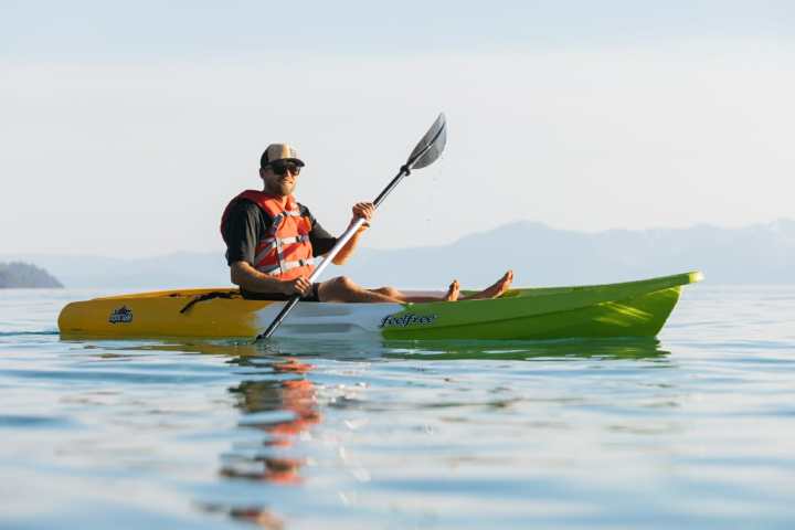 a man riding on the back of a boat on a body of water