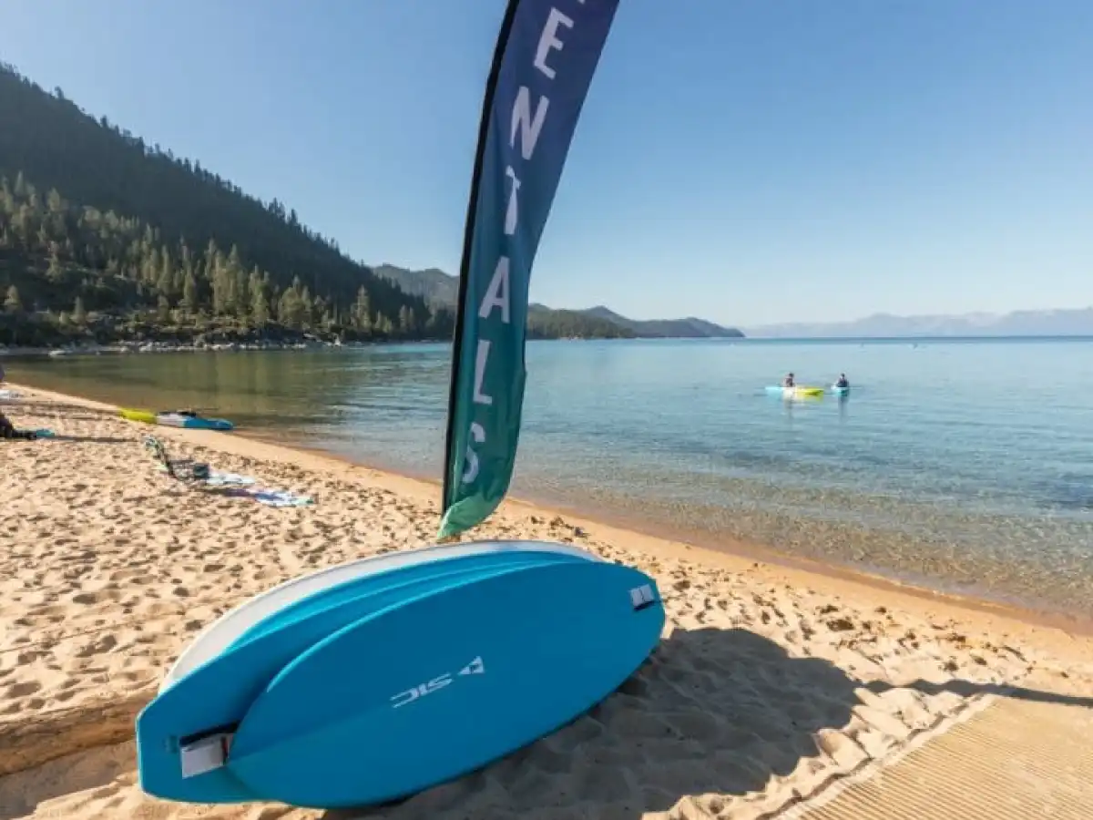 a beach with a surf board on a body of water