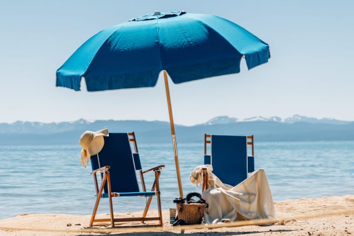 a couple of lawn chairs sitting on top of a beach