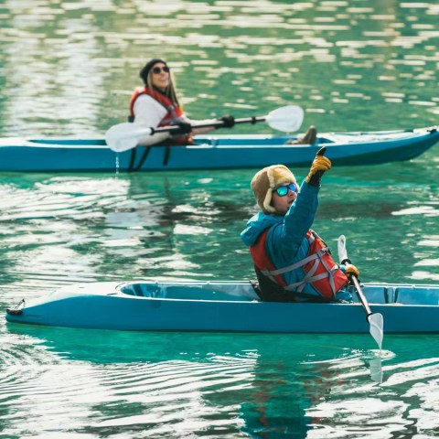a group of people rowing a boat in the water