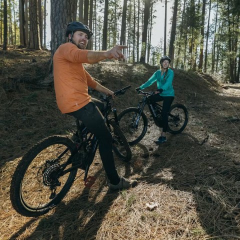 a man riding a motorcycle down a dirt road